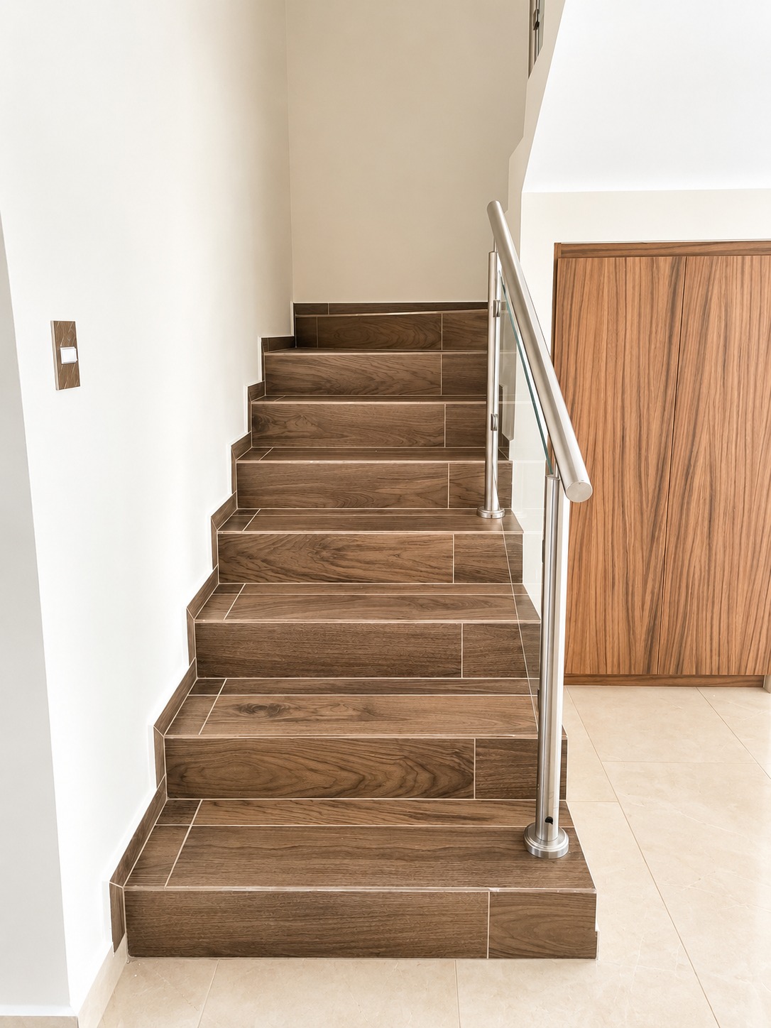 Escalera con peldaños de madera, barandal de acero inoxidable y cristal templado